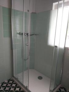 a shower with a glass door in a bathroom at Zimmerhäusl in Schlitters
