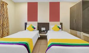 two beds in a room with colorful stripes at Hotel G Square in Vijayawāda +10 photos