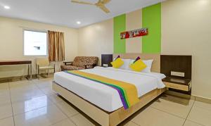 a bedroom with a large bed and a chair at Hotel G Square in Vijayawāda