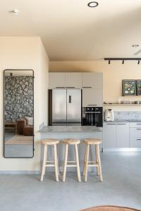 a kitchen with two wooden stools and a counter at Villa Lum - BY Harim in Eilat