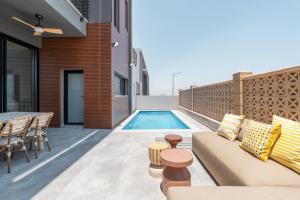 a patio with a couch and a swimming pool at Villa Lum - BY Harim in Eilat