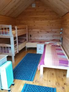 a room with two bunk beds in a cabin at Loopre Vesiveski puhketalu in Loopre