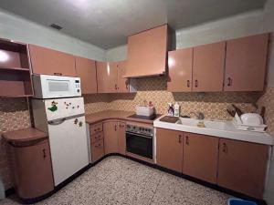 a kitchen with wooden cabinets and a white refrigerator at 住在巴黎 in Bondy