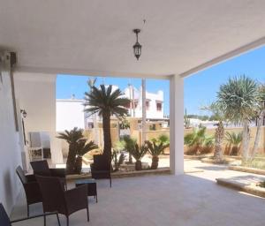 a living room with a view of palm trees at Villa Blu Dea room & apartment in Torre Lapillo