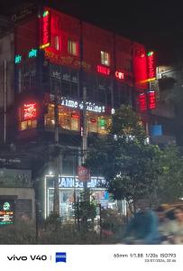 a building with neon signs on the side of it at Hotel The One Point, Uttara in Bāiljuri