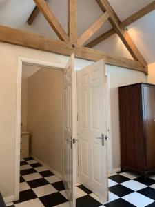 a room with a white door and a checkered floor at Lodge 1, The Grange in Wick +5 photos