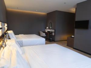 a hotel room with two beds and a television at Merchant Hotel in George Town +61 photos