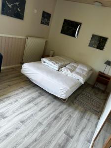 a bedroom with a white bed and a wooden floor at Eventyrborgen in Eskilstrup +9 photos
