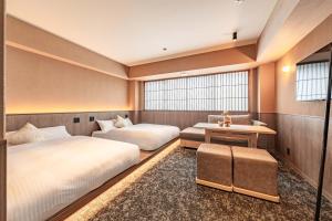 a room with two beds and a table and two windows at Apartment Hotel 11 Gion in Kyoto