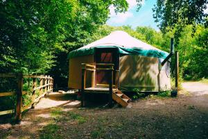 a yurt with a wooden fence in a field at Yurtcamp Devon in Heathfield