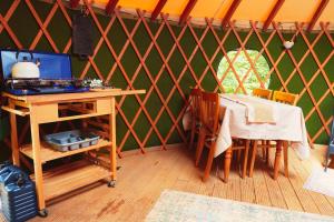 a room with a table and chairs in a yurt at Yurtcamp Devon in Heathfield