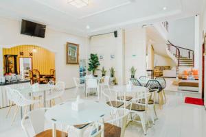 a dining room with white tables and chairs at Aleyra Hotel and Villa's Garut in Garut