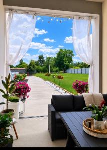 a patio with a couch and a walkway with flowers at Apartman Ćosić in Kruševica