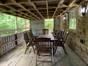 a porch with a table and chairs on it at Lodge 1, The Grange in Wick