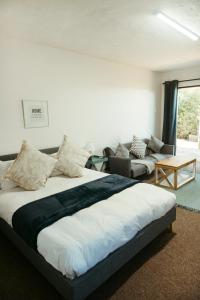a bedroom with a large bed and a couch at Idylla Guest Home in Kenton on Sea