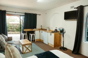a living room with a kitchen and a table at Idylla Guest Home in Kenton on Sea