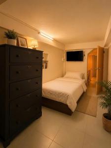 a bedroom with a bed with a dresser and a tv at Lê Gia Homestay 2 in Hue