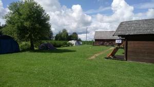 a yard with tents and a building and a house at Loopre Vesiveski puhketalu in Loopre
