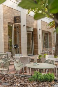 Eine Gruppe von Tischen und Stühlen vor einem Gebäude in der Unterkunft Hotel HOGO in Inđija