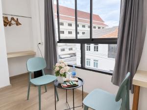 a room with a table and two chairs and a window at The 789 House in Chiang Mai