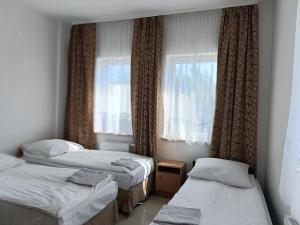 a bedroom with two beds and a window at Hostel Wólka Kosowska z prywatnymi łazienkami in Wólka Kosowska +83 photos