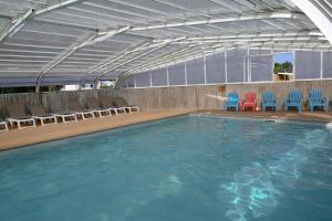 a swimming pool with chairs and a pool of water at Camping Domaine du Morbihan in Ambon