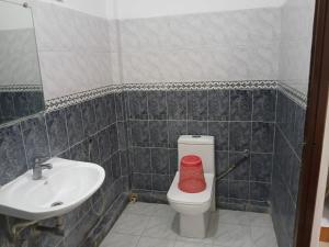 a bathroom with a white toilet and a sink at Cross Bill Beach Resort in Havelock Island