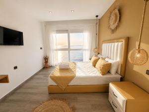 a bedroom with a large bed with a window at Sensia Mediterranean Escape in Aouchtame