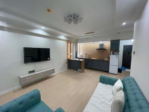 a living room with a blue couch and a tv at Amarida residence in Erdenet