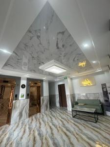 a lobby with a marble ceiling and a green couch at Amarida residence in Erdenet