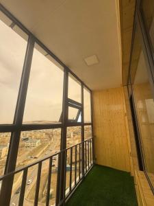 a room with a large window with a green floor at Amarida residence in Erdenet