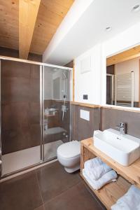a bathroom with a shower and a toilet and a sink at Chalet Brento in Lundo