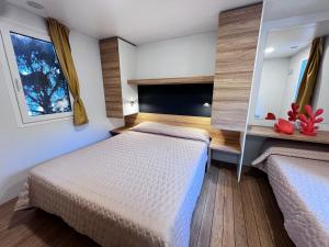 a bedroom with two beds and two windows at Dune Prestige & Chalets in Bibione +260 photos