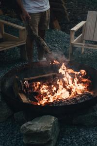 a man is standing next to a fire in a grill at Bon Air Club in Saint-Léonard-des-Bois