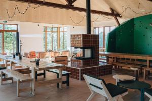 a large room with tables and a fireplace at Bon Air Club in Saint-Léonard-des-Bois