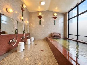 a large bathroom with a swimming pool in a building at Matsue Universal Hotel in Matsue