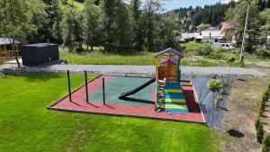 a small playground with a slide in a yard at Complex turistic Casa Diaconu in Breaza
