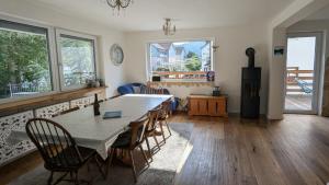 a dining room with a table and chairs and windows at Forest Lodge - perfekt für Familien und Freunde in Bayerisch Eisenstein