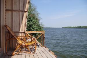 a couple of chairs sitting on a dock next to the water at Bamboo Bungalow in Kampot