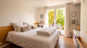 a bedroom with a large white bed with a window at Les sapins verts - vue haras in Saint Lo