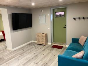 a living room with a blue couch and a flat screen tv at Arkaadia in Viljandi