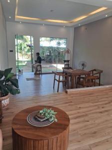 a living room with a table and a person sitting in a chair at Galle Wonvil Apartment in Galle