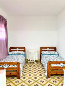 two beds in a room with a table at Relax in Oued Laou in Oued Laou
