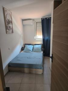 a small bedroom with a bed and a window at small and cozy in Perpignan