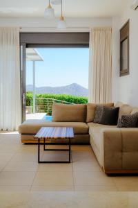 a living room with a couch and a table at Apollonia Elounda View Villa in Elounda