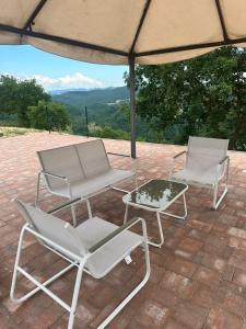 two chairs and a coffee table under an umbrella at Villa Sant' Andrea in Gubbio +29 photos