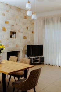 a living room with a table and a television at Apollonia Elounda View Villa in Elounda +34 photos