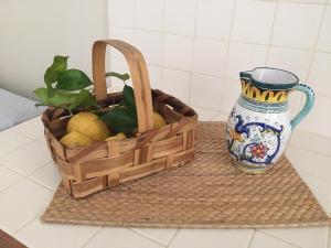 a basket of lemons sitting next to a vase at Da zio Totò in Scilla +4 photos