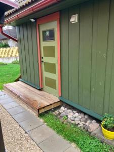a green house with a door and a wooden porch at Arkaadia in Viljandi