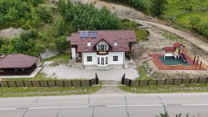a white house with a red roof and a yard at Casa Diaconu in Fundu Moldovei